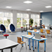 An open-concept, flexible classroom space with desks, chairs, and stools. 