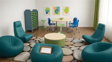 A rendering of a classroom space with soft seating, chairs, ottoman, table, stools and a nature-inspired rug. 