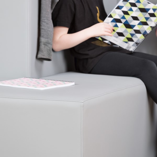 Student reading on the Shape Series II Vinyl Block Soft Seating Set