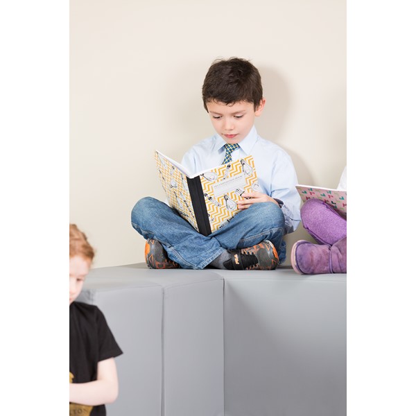Student reading on the Shape Series II Vinyl Block Soft Seating Set
